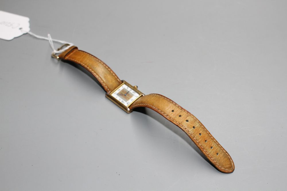 A ladys 925 gilt Must de Cartier Vermeil Tank quartz wrist watch, on associated strap.